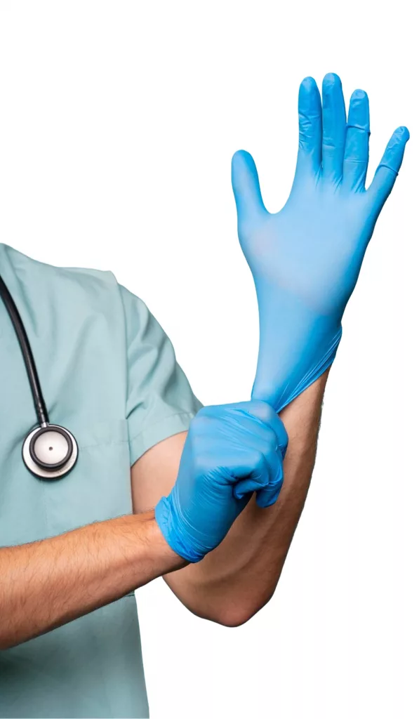 Ein Arzt in grüner Kleidung mit Stethoskop zieht sich einen blauen Einweghandschuh über die Hand – symbolisch für Hygiene, Vorbereitung und medizinische Sorgfalt.