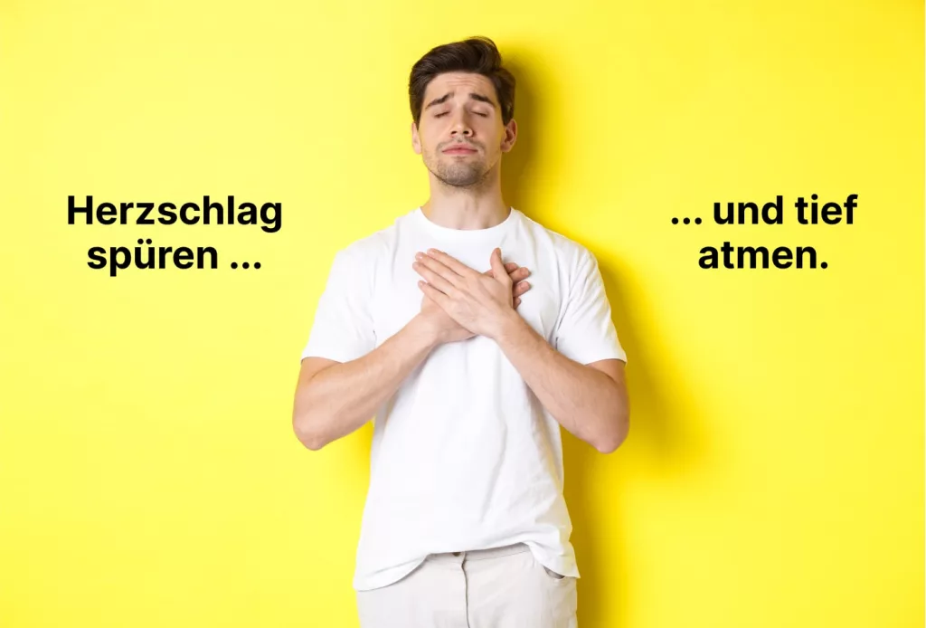 Ein Mann in einem weißen Hemd steht vor einem gelben Hintergrund, die Hände auf der Brust, die Augen geschlossen. Der deutsche Text lautet "Herzschlag spüren ... und tief atmen.