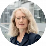 Ein Portrait von Diana Runge vor einem Gebäude mit Glaswänden.