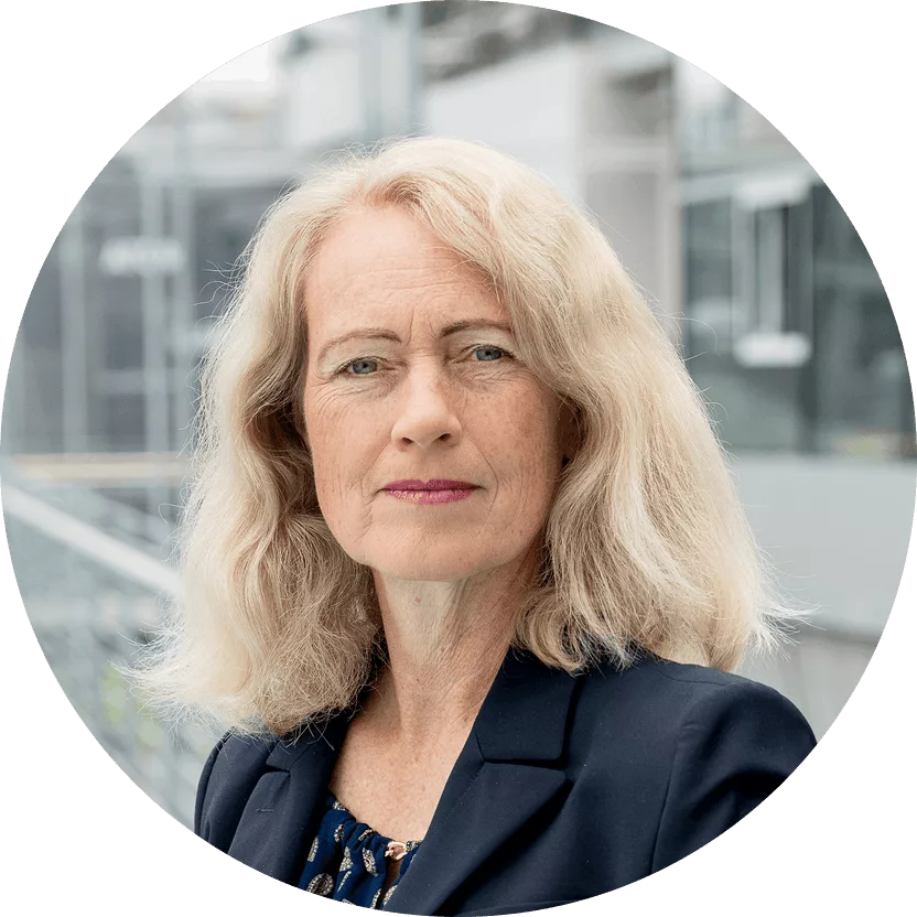 Ein Portrait von Diana Runge vor einem Gebäude mit Glaswänden.