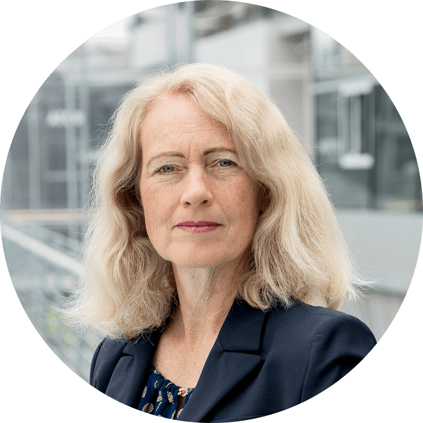 Ein Portrait von Diana Runge vor einem Gebäude mit Glaswänden.